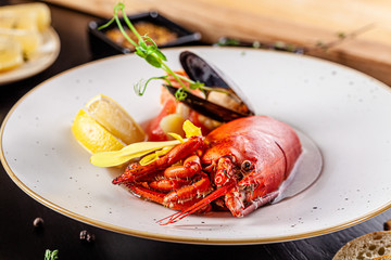 French cuisine concept. Crab fish soup with seafood, with salmon, scallop, squid, mussels. Serving dishes in a restaurant in a white plate. background image. copy space.