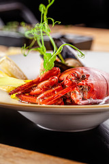 French cuisine concept. Crab fish soup with seafood, with salmon, scallop, squid, mussels. Serving dishes in a restaurant in a white plate. background image. copy space.
