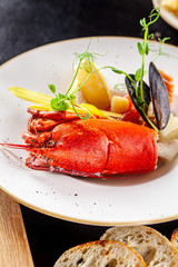French cuisine concept. Crab fish soup with seafood, with salmon, scallop, squid, mussels. Serving dishes in a restaurant in a white plate. background image. copy space.