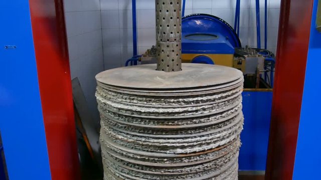 synthetic fiber discs drilled in the center where the oil paste is placed to be pressed by a hydraulic press to obtain olive oil