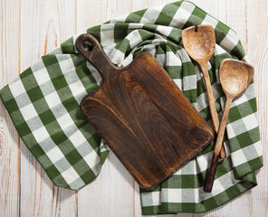 Cutting board over towel on wooden kitchen table. Top view © missty