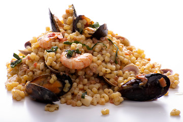 fregola sarda con frutti di mare su fondo bianco