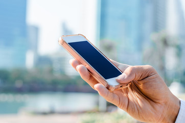 5G technology world wide web connecting.close up business man using hand typing smartphones and touch screen working search with app devices outdoor in city with sunrise and building background.