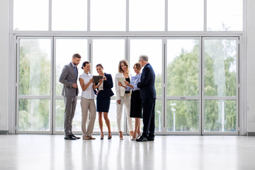 people, technology, work and corporate concept - business team with tablet pc computers at office