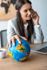 selective focus of travel agent holding hand on globe