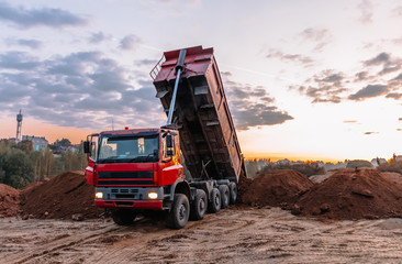 A dump truck is dumping gravel on an excavation site © Hanna