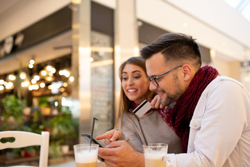 A couple at a mall checking an app store.