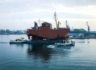 Fototapeta premium Transportation of the hull of a new fishing vessel on the pontoon in Shipyard Gdansk, Poland, natural light.