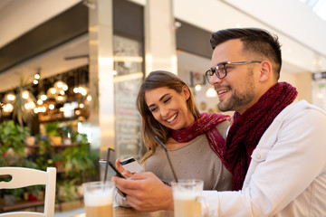 A couple using a shopping app and paying by card.