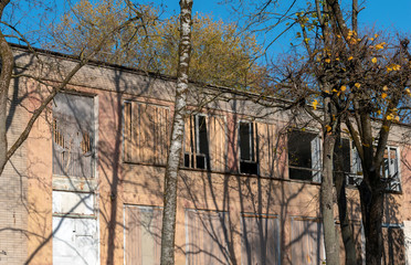 Fototapeta na wymiar Old brick abandoned building with trees overgrown