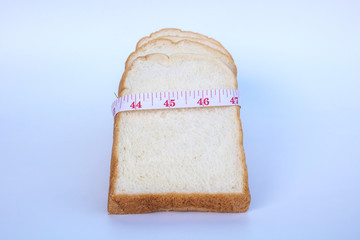 Slide bread with measuring tape on a white background.