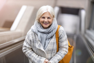 Happy Senior Woman On Escalator