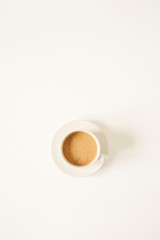Cup of coffee with milk on white table. Minimal morning breakfast concept. Flatlay, top view.