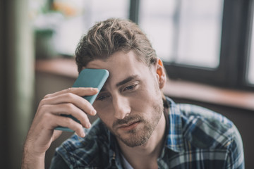 Tired and frustrated men holding his mobile phone