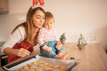 A mom and a child in the kitchen baking Christmas cookies.