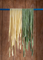 View of homemade pasta; hanging traditional and colored with spinach pasta