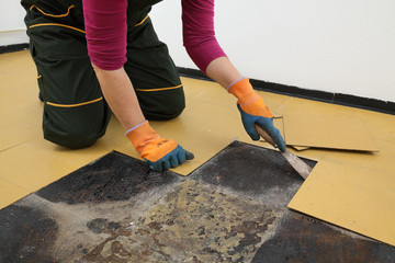 Old vinyl tiles removal from floor in a room or kitchen