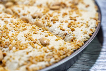 Plate of traditional Middle East tasty sliced halva on wooden board. Iranian  handmade sweet with almond.
