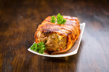 baked roulade of minced meat surrounded by bacon