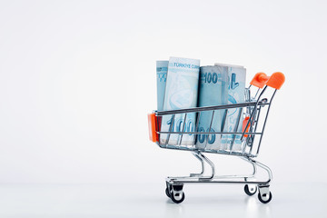 Shopping cart trolley full of Turkish lira bills on white background
