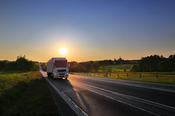 White Truck transport on the road and cargo at sunset