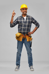 profession, construction and building - happy smiling indian worker or builder in helmet with tool belt having idea over grey background