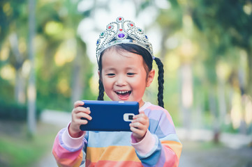 little girl is taking a selfie , When she crowned the princess on head her smile with happy face © jes2uphoto