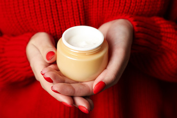 Woman holding jar of moisturizing cream, closeup. Winter cosmetic. Space for text