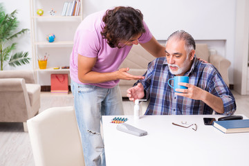 Fototapeta premium Young student and his old grandpa at home