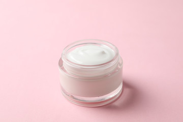 Jar of winter cream for skin on pink background, space for text. Closeup