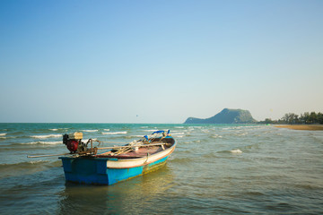 local boat seaside have mountain and clear sky background in Thailand