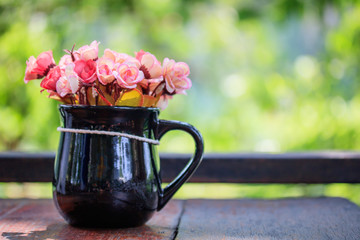 Vase with artificial flowers on a natural background.