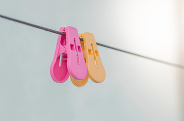 plastic​ clothespins pink​ and yellow color​​ ​ on​ wall background, Colorful plastic clothespins on the hangers.