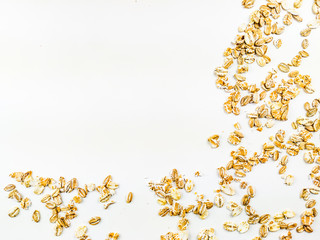 Healthy and golden yellow oat grain flake cereal placed on one corner of the image on a white background forming a frame of healthy food