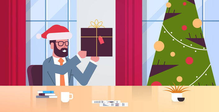 business man holding gift present box businessman sitting at workplace merry christmas happy new year winter holidays celebration concept modern office interior flat portrait horizontal vector