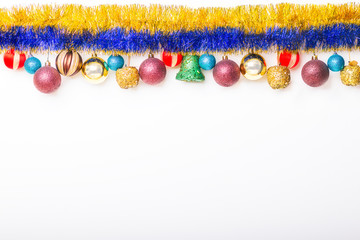 Świąteczne ozdoby - Kolorowe ozdobne łańcuch i bombki choinkowe. Świąteczne tło - ozdoby zwisające z góry.