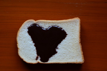 Heart shaped of chocolate syrup on bread over wood table , can use for love and Valentine concepts....