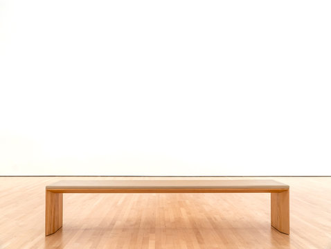 White room in a museum with a bench