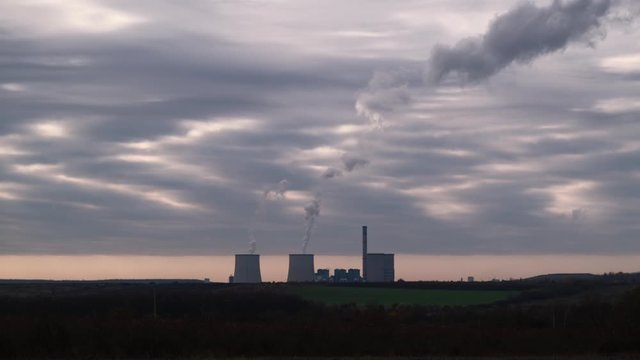 Visonta Power plant block. Water vapor rises to the sky. Energy poles and chimneys in the background.