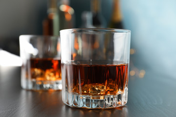 Glasses of whiskey on bar counter, close up and space for text