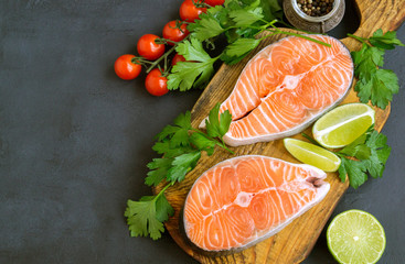 Salmon steak raw fish prepared for cooking. Top view on black table.