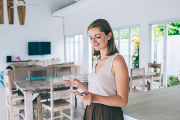 Cheerful freelance woman using phone at work space