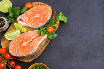 Salmon steak raw fish prepared for cooking. Top view on black table.