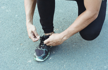 Fototapeta na wymiar Sport runner tying laces of running shoes before exercise. Healthy and lifestyle concept.