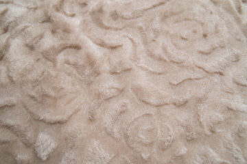 Fluffy beige plaid background, close up. Delicate baby pastel fabric with waves and pleats. Wrinkled beige warm blanket background