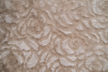 Fluffy beige plaid background, close up. Delicate baby pastel fabric with waves and pleats. Wrinkled beige warm blanket background