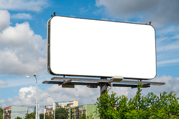 Blank white billboard for advertisement in the city. Sumeer day, blue sky with some white clouds.