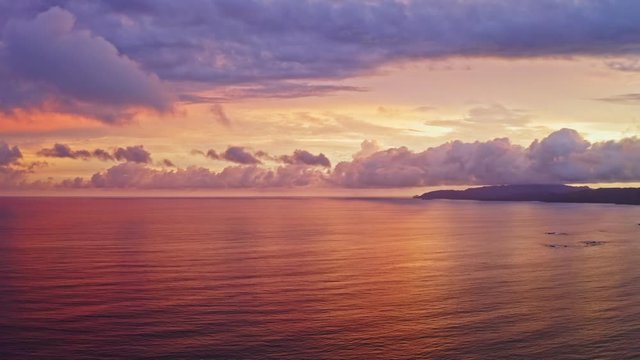 4K Wide Aerial Drone Shot of Beautiful Sunset over the Beach of Tambor, Costa Rica.
Saturated colorful Sunset with Fluffy Clouds and Amazing Reflection on the Ocean.