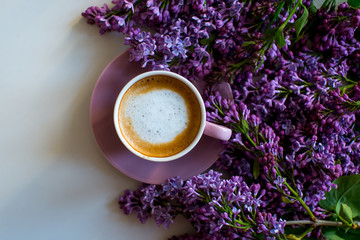 Obraz na płótnie Canvas Floral composition made of beautiful purple lilac, syringa flowers on white background with cup of coffee. Feminine office desk, styled stock image, flat lay, top view with empty space.