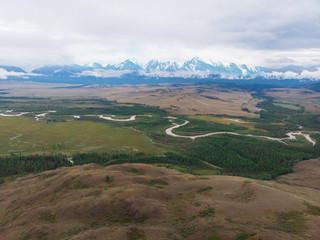 Fototapeta na wymiar Aerial view of Kurai steppe and Chuya river on North-Chui ridge background. Altai mountains, Russia.